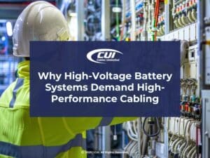 Featured: Worker in yellow safety jacket working on electrical panel- Why High-Voltage Battery Systems Demand High-Performance Cabling.