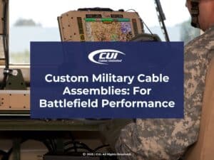 Soldier operating military computer viewing digital map- Custom Military Cable Assemblies for Battlefield Performance.
